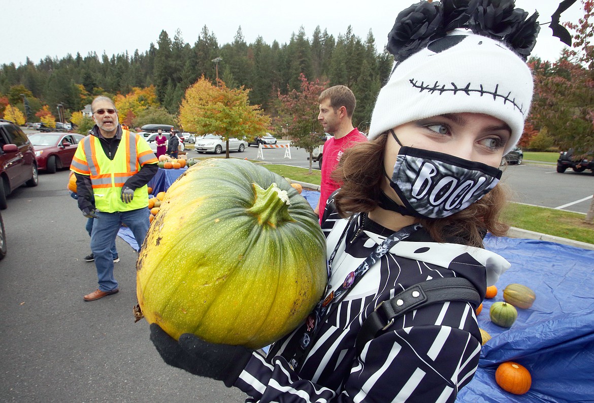 Coeur d'Alene Public Library Clerk Loren Roberts carries a pumpkin to a vehicle the pumpkin giveaway outside City Hall on Oct. 15.