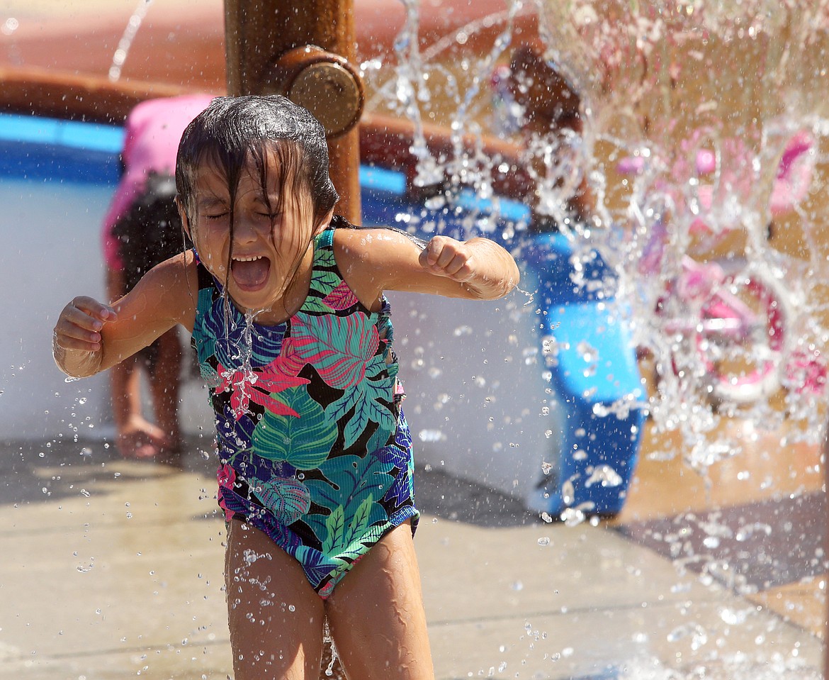 Violet Gagnon reacts after doused with cold water at the splash pad at McEuen Park on June 30.