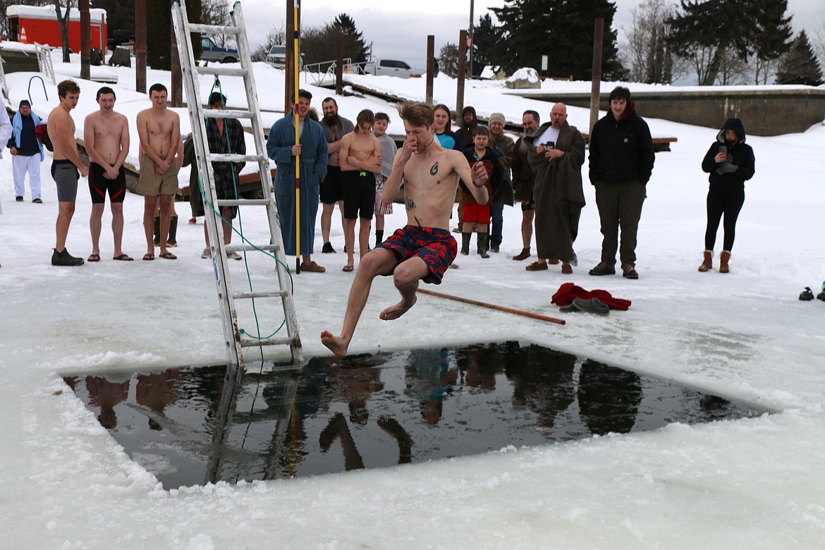 Jeremiah Voelz, home from the U.S. Navy on Christmas leave, jumps into the frigid waters of Lake Pend Oreille on Saturday. Voelz, the son of Boy Scout Troop 111 Scoutmaster Phil Voelz, was one of several dozen taking part in the event.