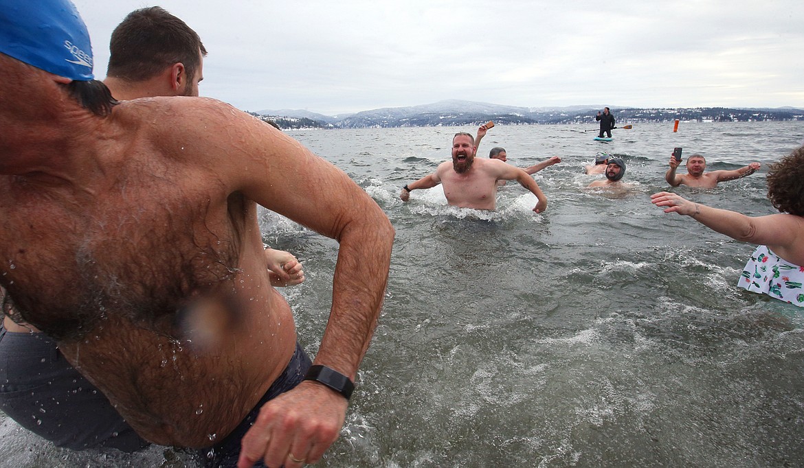 People rush out of Lake Coeur d'Alene at Sanders Beach on Saturday after taking part in the Polar Bear Plunge.