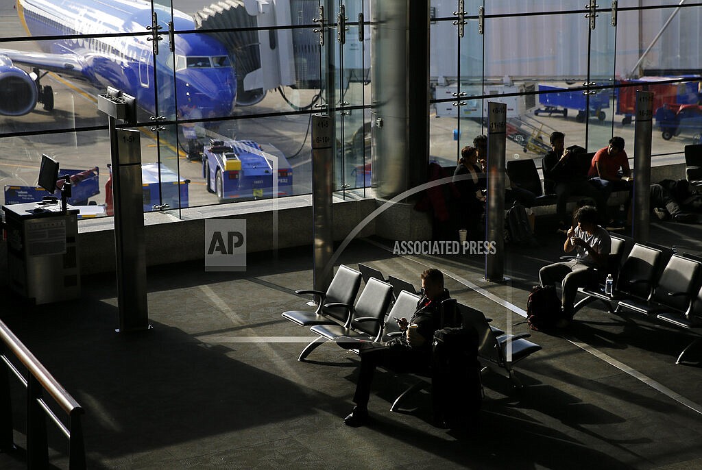 Travelers sit at a gate at Baltimore-Washington International Thurgood Marshall Airport, Nov. 20, 2018, in Linthicum, Md. A winter storm moving into the mid-Atlantic combined with the pandemic to continue frustrating air travelers whose return flights home from the holidays were canceled or delayed in the first few days of the new year. More than 1,900 U.S. flights and more than 3,300 worldwide were grounded as of early Monday, Jan. 3, 2022 according to tracking service FlightAware. That follows Sunday’s cancellations of more than 2,600 U.S. flights, and more than 4,400 worldwide. (AP Photo/Patrick Semansky, file)