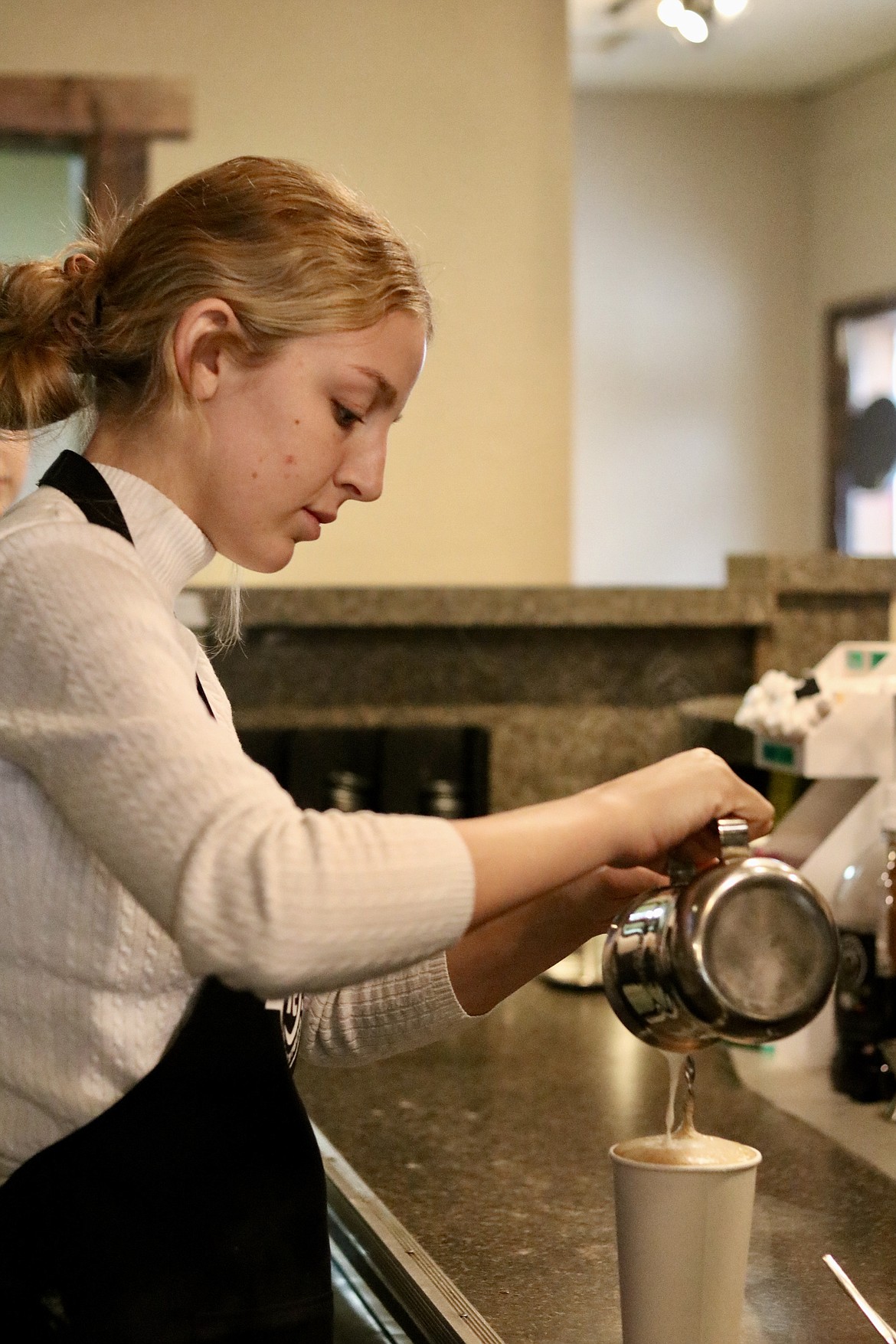 Baylie Miller of Lyfe Coffee Roasters and Public House in downtown Coeur d'Alene makes a beverage on Monday. The coffee shop, formerly known as Calypsos Coffee Roasters, reopened under new ownership on Sunday. HANNAH NEFF/Press