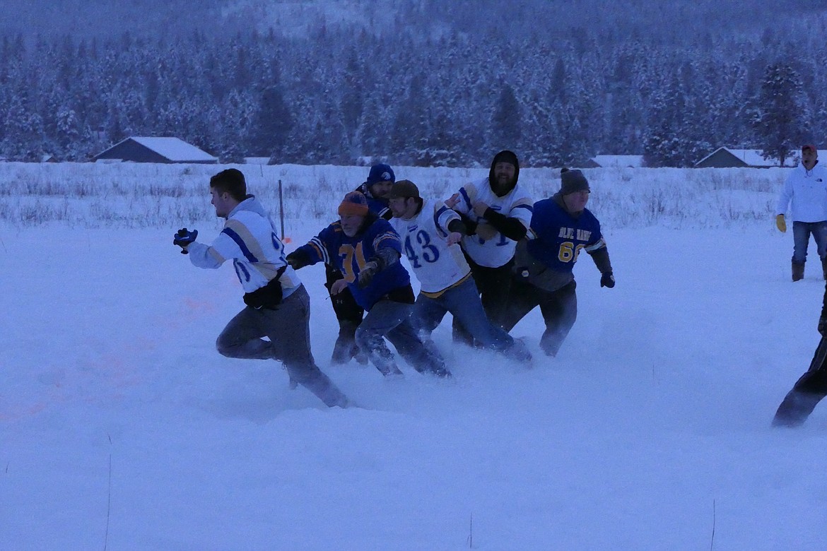 The Big Boys on both office lines kick up snow as they rush the passer during the Keg Bowl's first half. (Chuck Bandel/Valley Press).