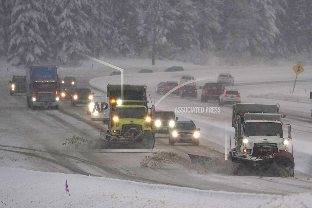 Washington Dept. of Transportation snow plows work on a stretch of eastbound Interstate Highway 90, Dec. 9, 2021, as snow falls near Snoqualmie Pass in Washington state. Authorities say Snoqualmie Pass in Washington state has received the highest snowfall in 20 years as of Jan. 3, 2022. The Washington State Department of Transportation said by Monday afternoon, Jan. 3, 2022, 236 inches of snowfall was recorded, more than the 229 inches by Jan. 3 that was recorded in 2007 and 212 inches in 2004. (AP Photo/Ted S. Warren, File)