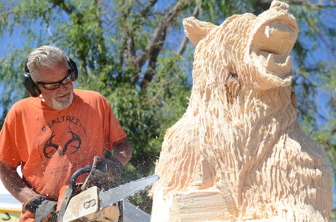 Todd Coats' prize-winning bear starts to appear out of a log after the first day of carving at the 2021 Ronan Chainsaw Rendezvous in May. (Carolyn Hidy/Lake County Leader)