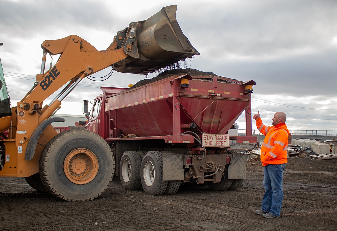 Grant County Public Works Department employee Scott Johnson signals his truck is full in preparation for a winter storm in January 2021.