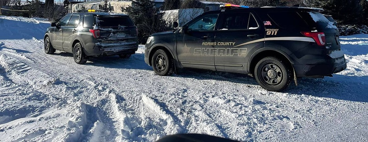 Adams County Sheriff’s Office deputies’ vehicles are shown near a structure fire in which a person was found dead.