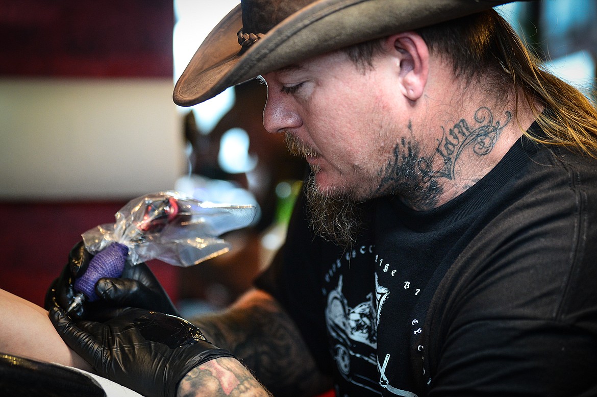 Ryan Swindler tattoos the forearm of Bridger Beach at Swindler Ink in Kalispell on Wednesday, Jan. 5. (Casey Kreider/Daily Inter Lake)