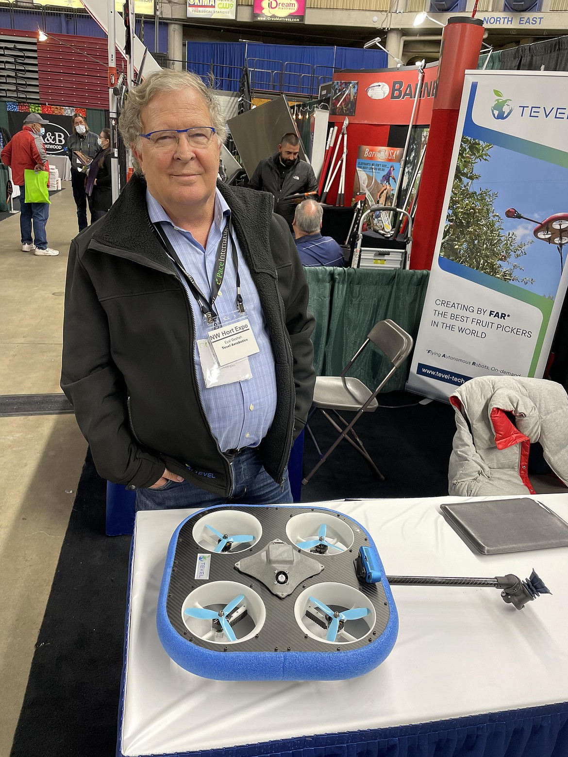 Tevel Aerobotics Technologies Board Chair Eyal Desheh stands behind one of the company’s specially designed fruit-picking drones.