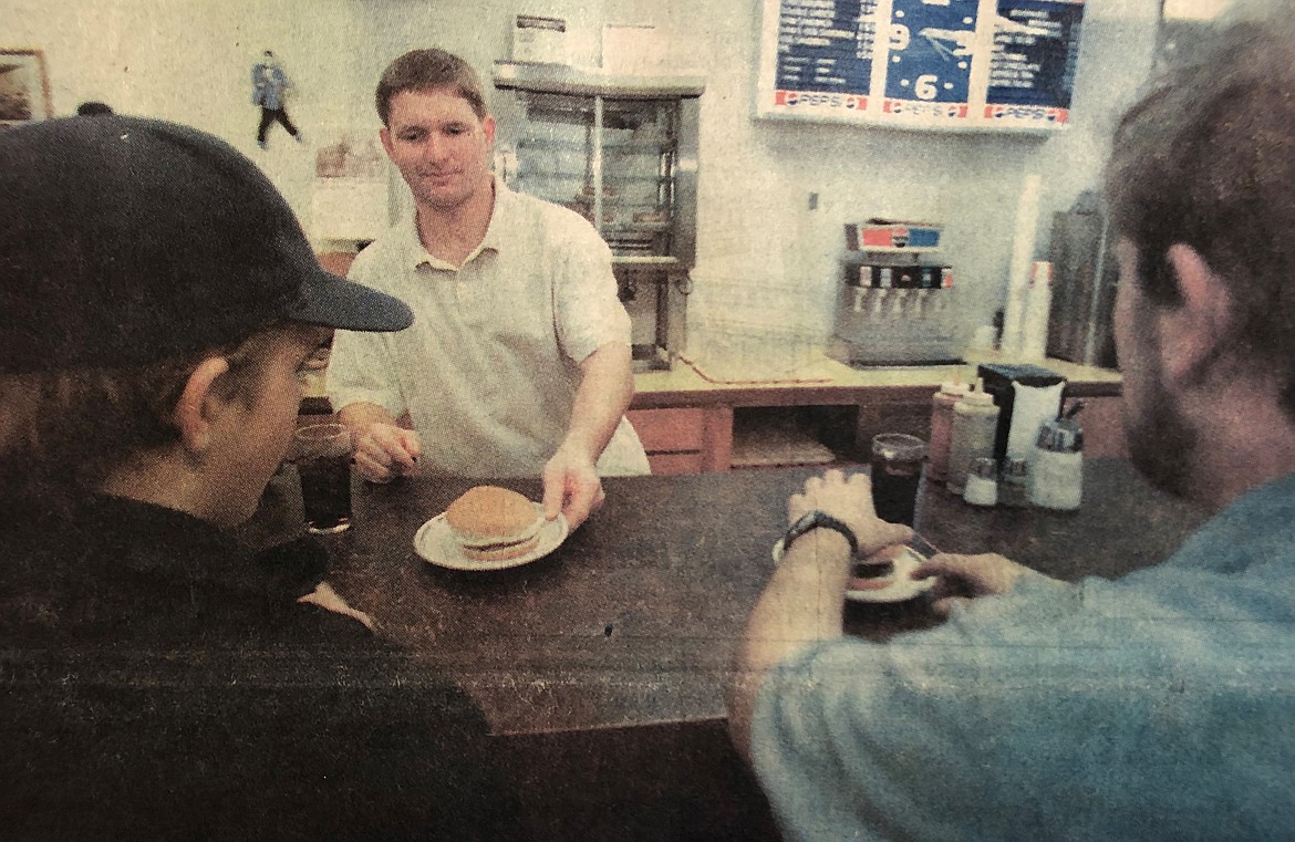 Steve Hudson of Hudson’s Hamburgers serves a final burger to lingering customers in 1997 after the city temporarily closed the popular restaurant which neighbored then-collapsing Wilma Theater.