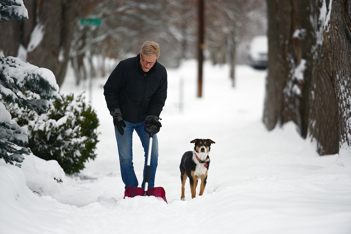 Bob Sherrick shovels snow with his dog Louie along Fourth Avenue East in Kalispell on Friday, Jan. 7. (Casey Kreider/Daily Inter Lake)