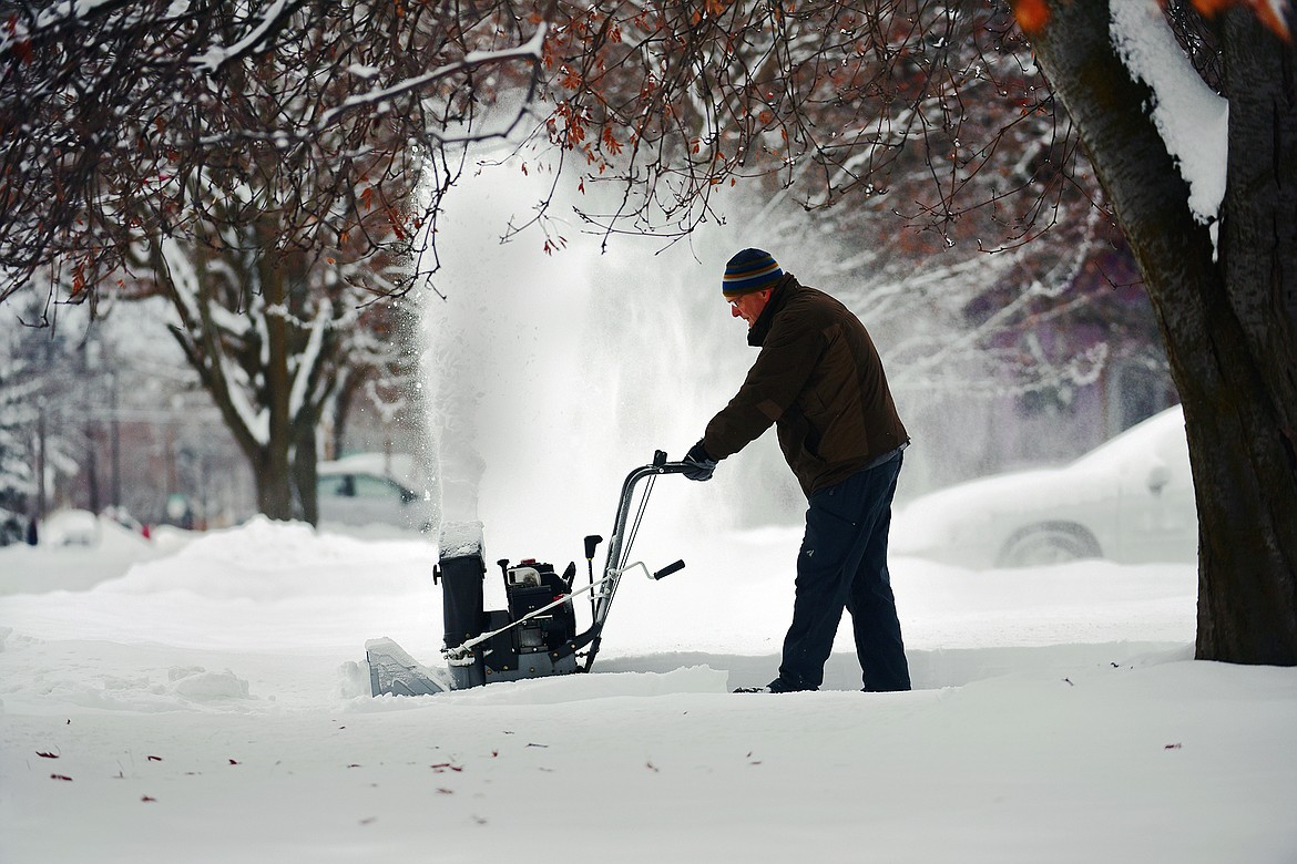 Ben Long clears snow along East California Street in Kalispell on Friday, Jan. 7. (Casey Kreider/Daily Inter Lake)