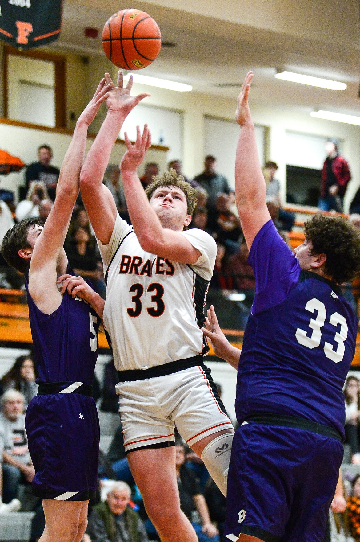 Flathead's Joe Hansen (33) looks to shoot between Butte defenders Jonas Sherman (5) and Kooper Klobucar (33) at Flathead High School on Friday, Jan. 7. (Casey Kreider/Daily Inter Lake)