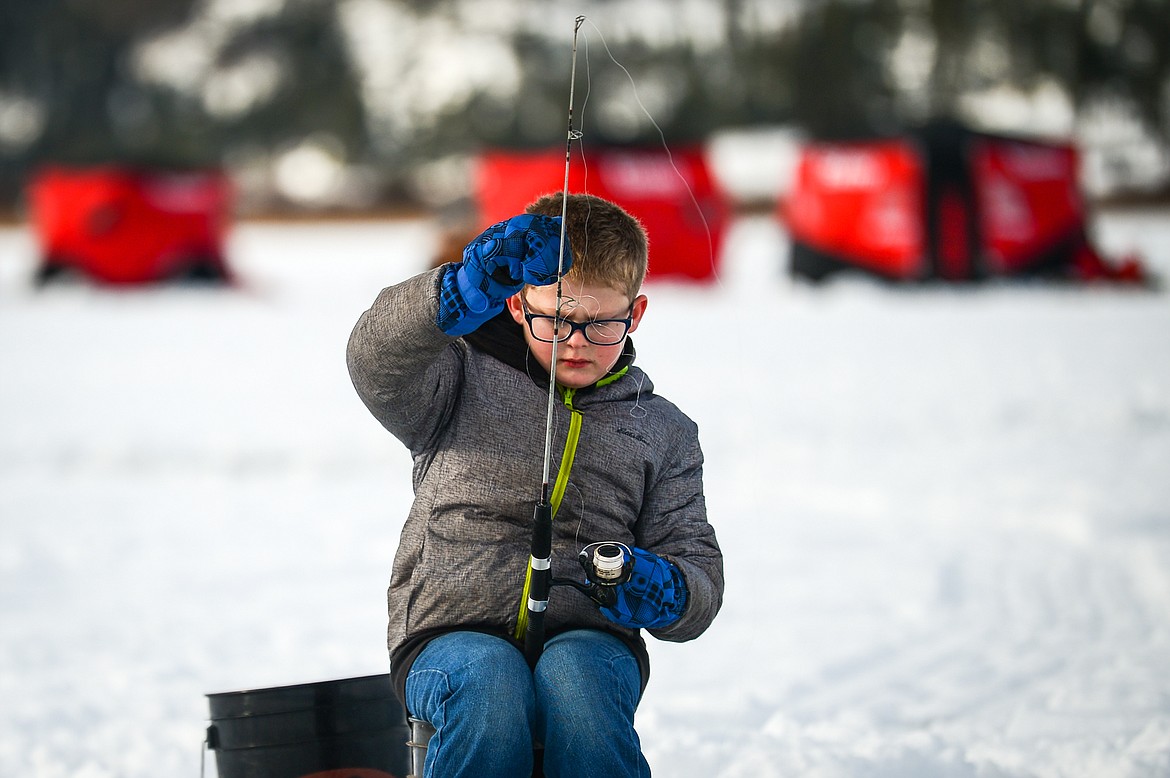 Trapper Hafer, from Creston, works to untangle his line without having to take his gloves off at the 51st Sunriser Lions Family Ice Fishing Derby at Smith Lake in Kila on Saturday, Jan. 8. (Casey Kreider/Daily Inter Lake)