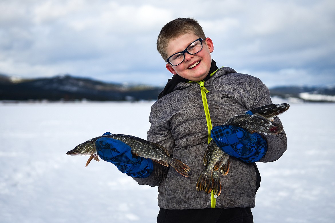 Trapper Hafer, from Creston, holds three of the pike he pulled out of Smith Lake at the 51st Sunriser Lions Family Ice Fishing Derby in Kila on Saturday, Jan. 8. (Casey Kreider/Daily Inter Lake)