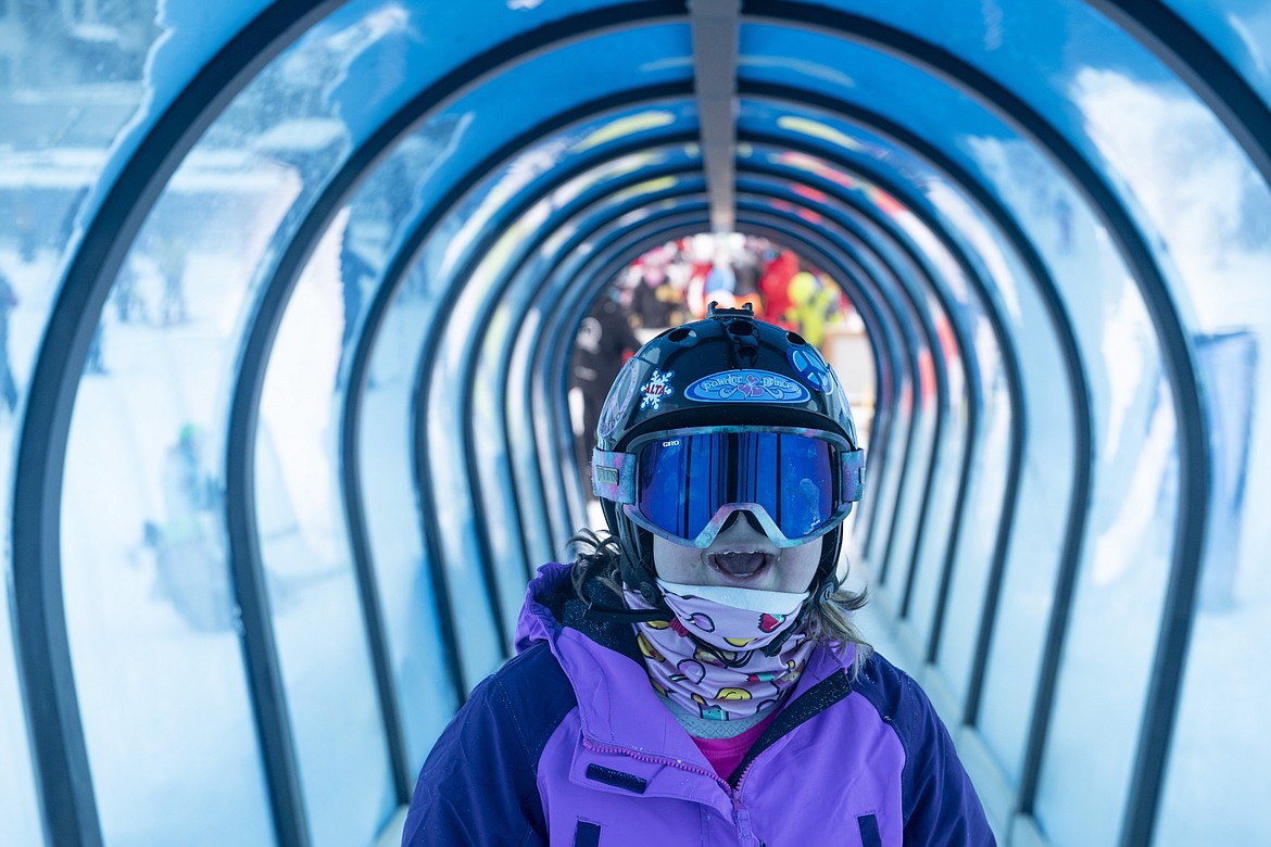 Eagle Mount participant Raechel Raether smiles as she rides a carpet lift during a ski lesson at Big Sky Resort on Dec. 29, 2021, in Big Sky, Mont. The group that provides outdoor recreation experiences is in its 40th year. (Samuel Wilson/Bozeman Daily Chronicle via AP)