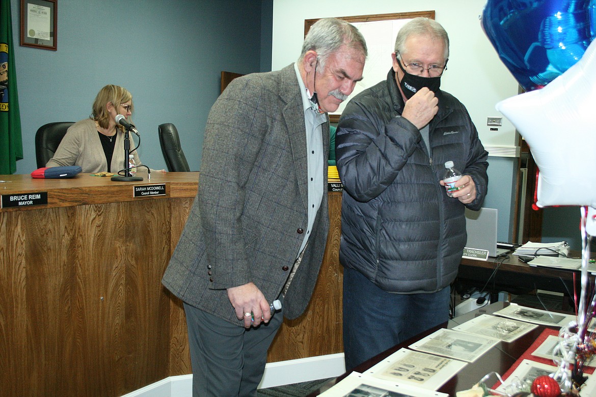 Retired Ephrata City Council member Mark Wanke, left, and former city employee Dennis Ohl look at pages from a scrapbook detailing Wanke’s 32 years on the council during a reception Dec. 15.