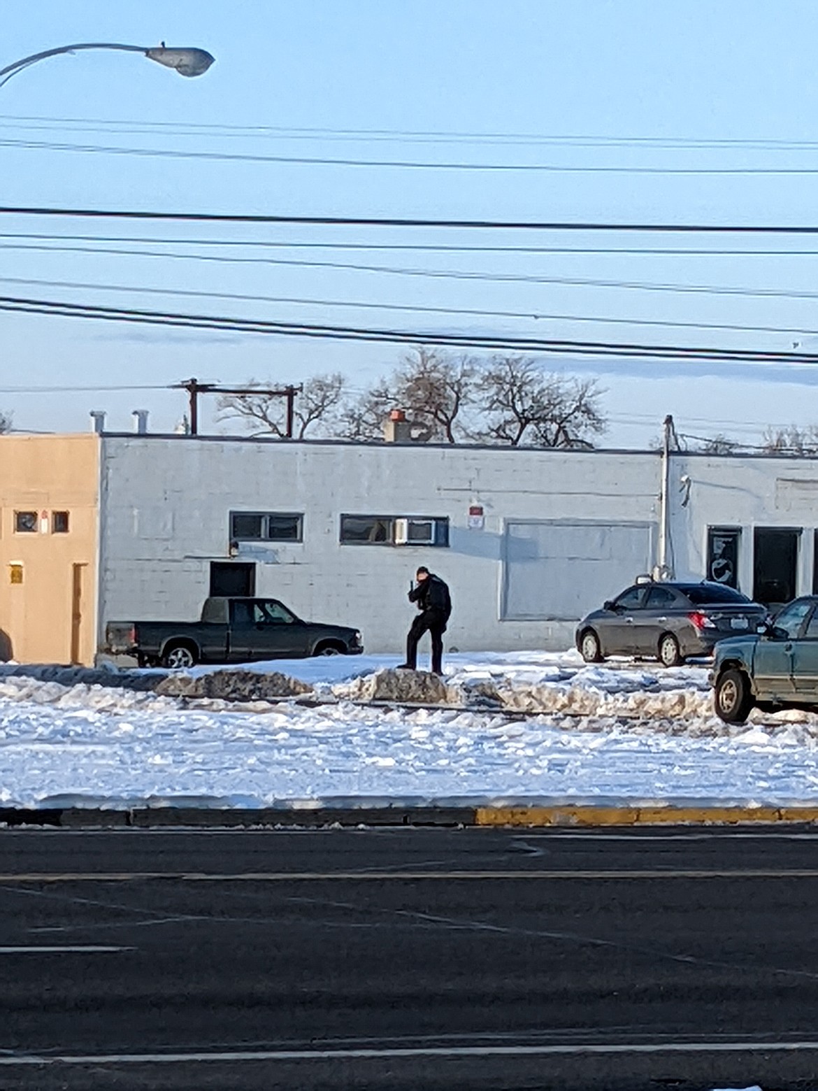 A Moses Lake Police Department officer looks for shell casings after an alleged drive-by shooting Monday afternoon on Gumwood Street.