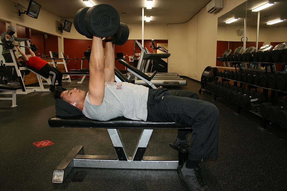 David Peralez works his arms with free weights Friday at the South Campus Athletic Club in Moses Lake.