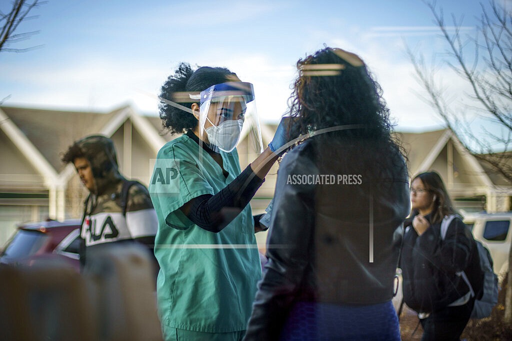 Maya Goode, a COVID-19 technician, performs a test on Jessica Sanchez outside Asthenis Pharmacy in Providence, R.I., Dec. 7, 2021. Scientists are seeing signals that COVID-19′s alarming omicron wave may have peaked in Britain and is about to do the same in the U.S., at which point cases may start dropping off dramatically. (AP Photo/David Goldman, File)