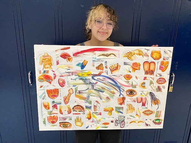 Val Mares, an eighth grader at Lakes Middle School, holds up her work, "Loving Differences," an artistic response to the reading of a play adaption of "The Diary of Anne Frank." Mares said she drew physical insecurities because a theme of the story was others being treated unfairly for their differences — the very things that make people unique. Courtesy photo.