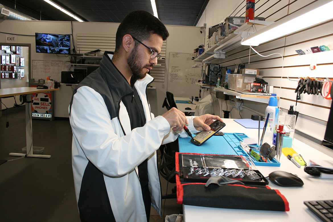 Saul Hinojosa works on a phone at the CPR Phone Repair in Moses Lake Tuesday.