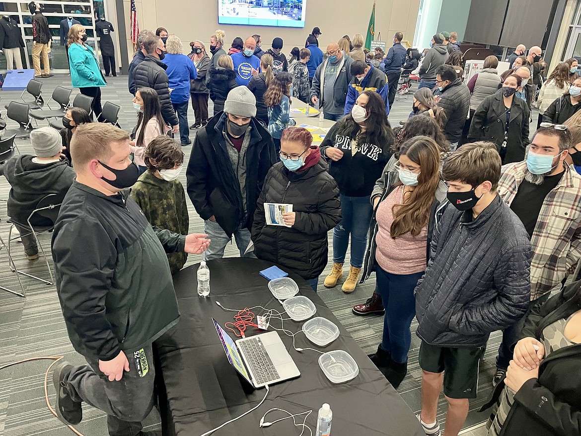 Drew Kostelnik, a teacher at the Moses Lake School District’s Vanguard Academy, which is scheduled to open this fall, demonstrates how electricity is conducted as part of a meeting for parents and prospective Vanguard Academy students at the Columbia Basin Technical Skills Center on Wednesday.