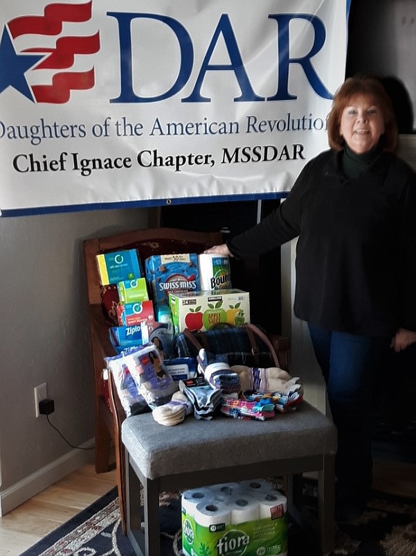 Cate Webber, regent for Kalispell's Chief Ignace Chapter of the Daughters of the American Revolution is pictured with donations the chapter collected for the Abbie Shelter.