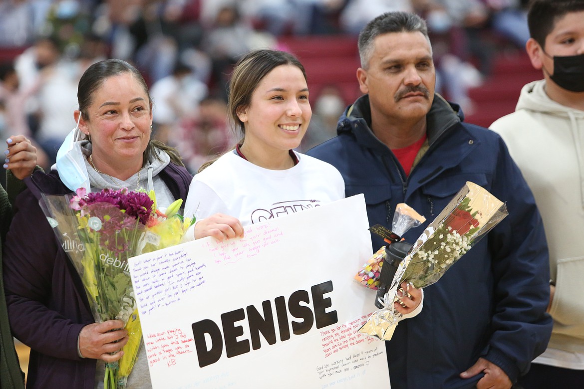 Wahluke High School senior Denise Caro (center), mom Baudelia Caro and dad Rafael Caro at half court on basketball Senior Night on Friday.