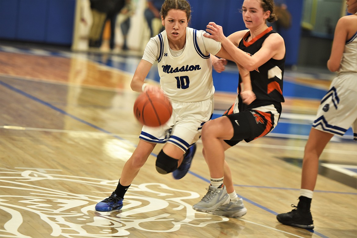 Mission senior Mady Currie dribbles past Ronan's Olivia Heiner. (Scot Heisel/Lake County Leader)