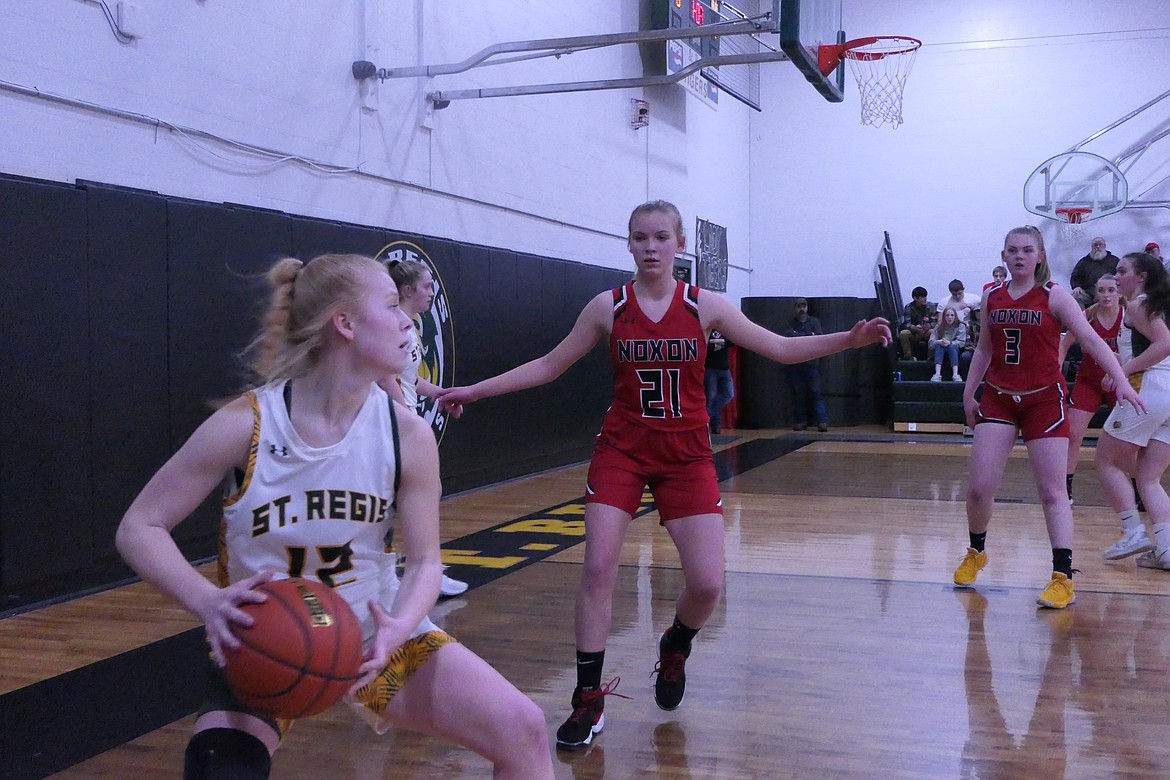 Noxon's Emma Swanson (21) prepares to check St. Regis' Macy Hill during Friday night's game in St. Regis.   (Chuck Bandel/Valley Press)