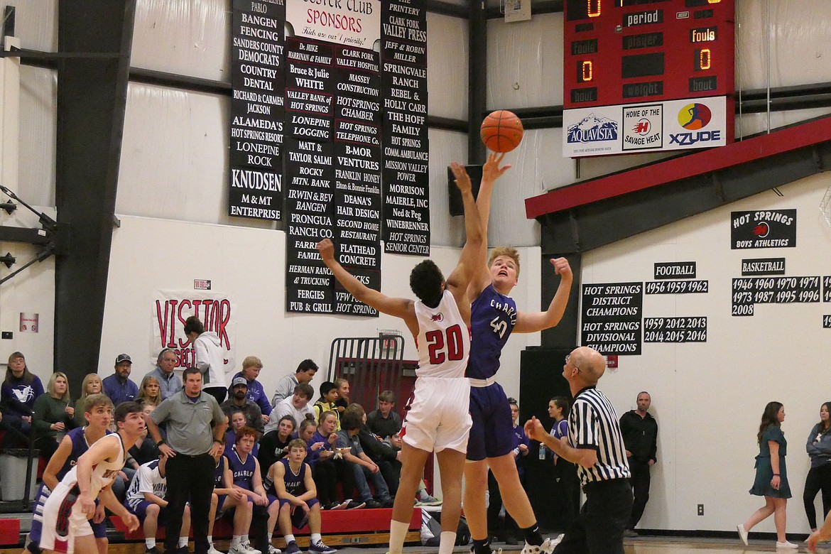 Charlo's Wesley Anderson out-jumps Hot Springs forward Nathan Lawhead (20) during the opening tip for Saturday night's last second win by Charlo.  (Chuck Bandel/Valley Press).