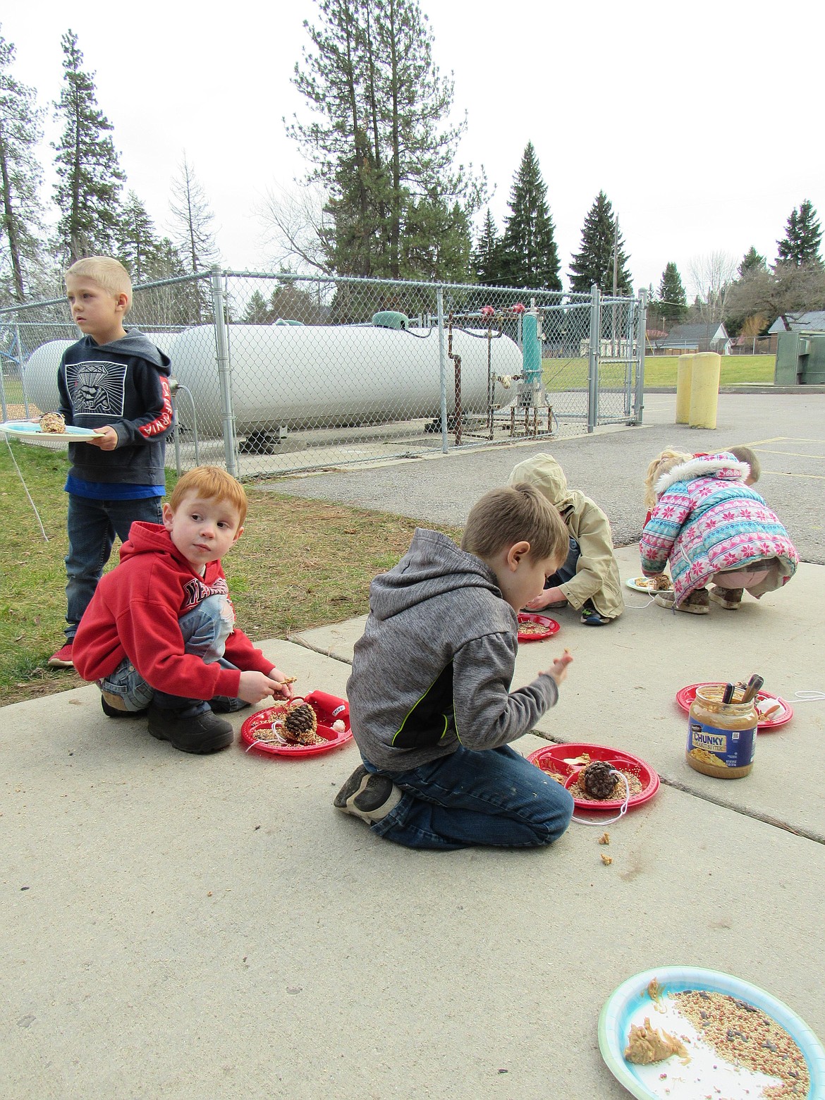 Idaho Hill Elementary students have fun making pine cone bird feeders at the school recently.