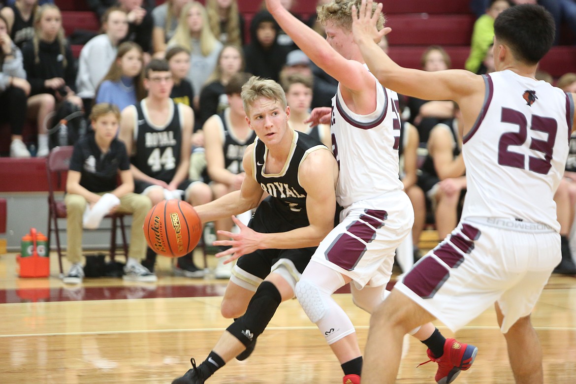 Luke Bergeson (2) of Royal High School drives for the basket against Andrew Yorgesen (32) of Wahluke High School and Orlando Nunez (23) in a league game Friday at Wahluke High School.
