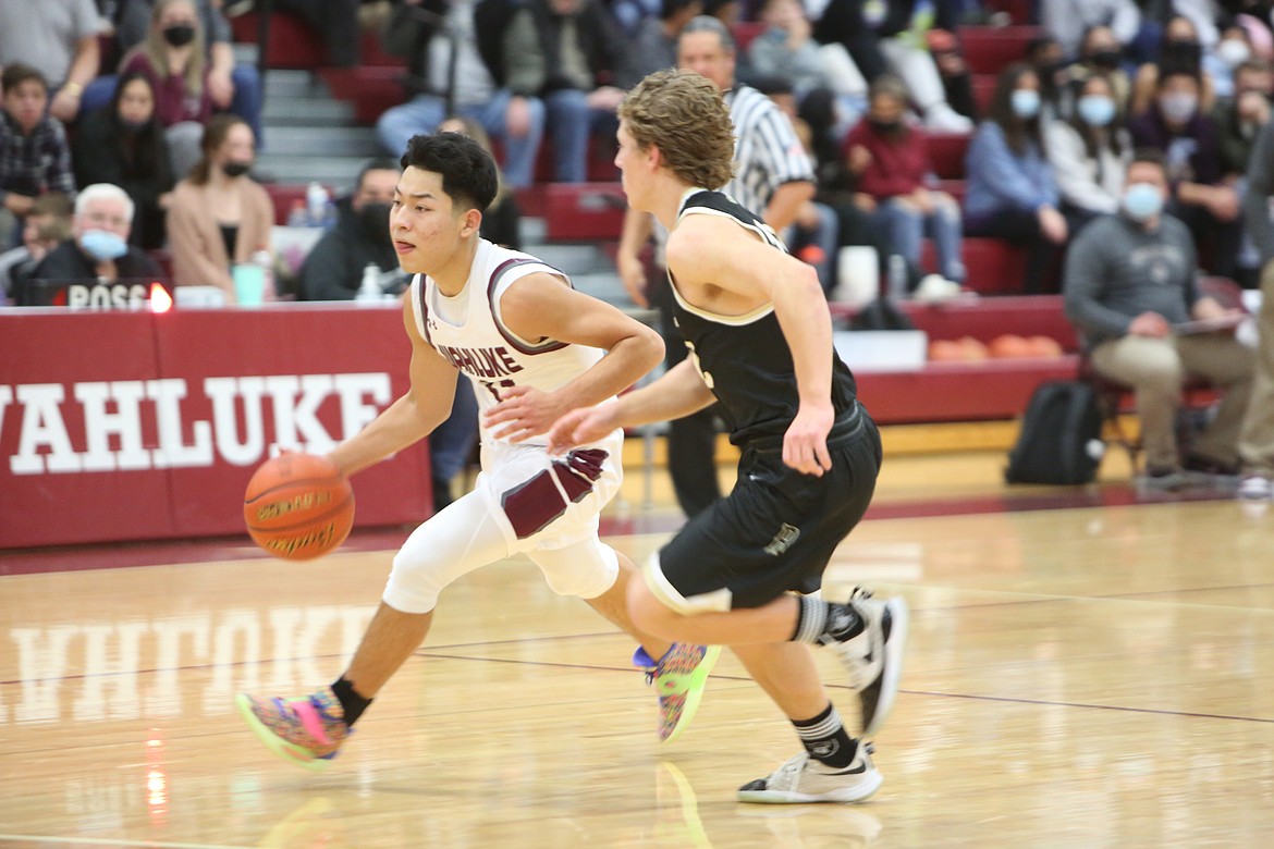 Maximiliano Urrutia (11) of Wahluke High School brings the ball up the court against Dylan Allred (32) of Royal High School during the Friday game at Wahluke High School.