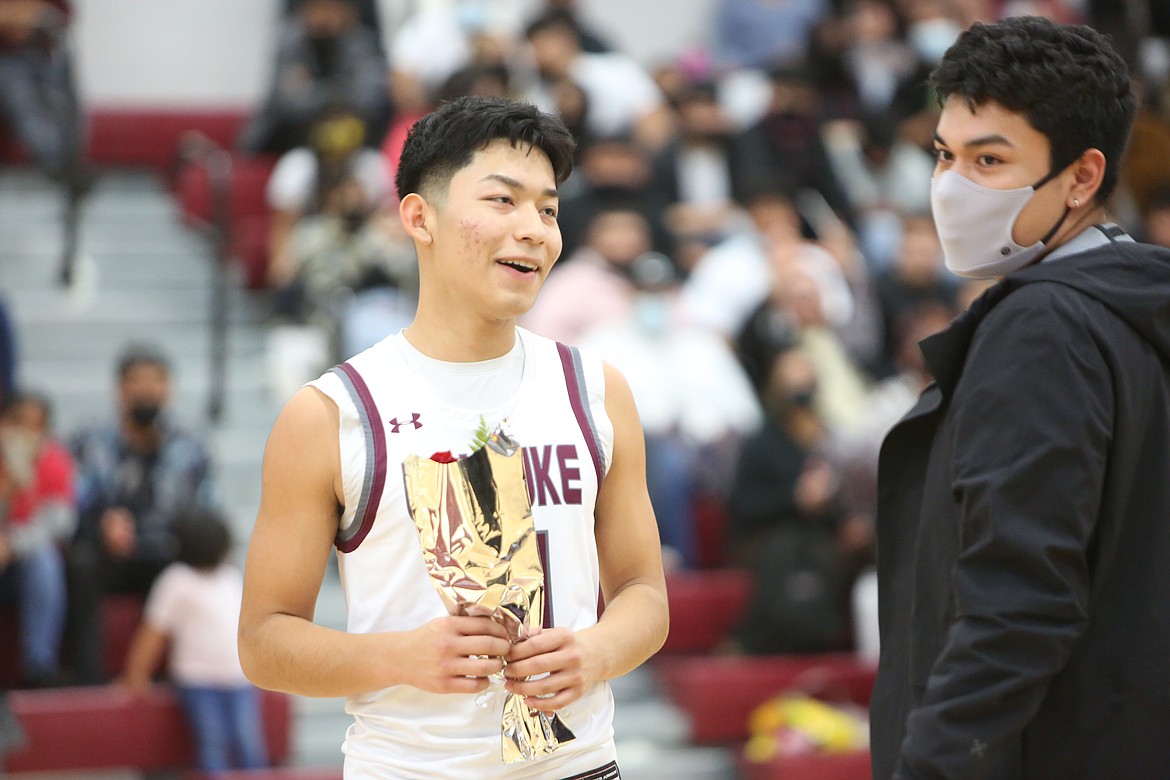 Maximilliano Urrutia (left), a senior at Wahluke High School, greets his brother Miguel Urrutia (right) at half court on basketball Senior Night on Friday.