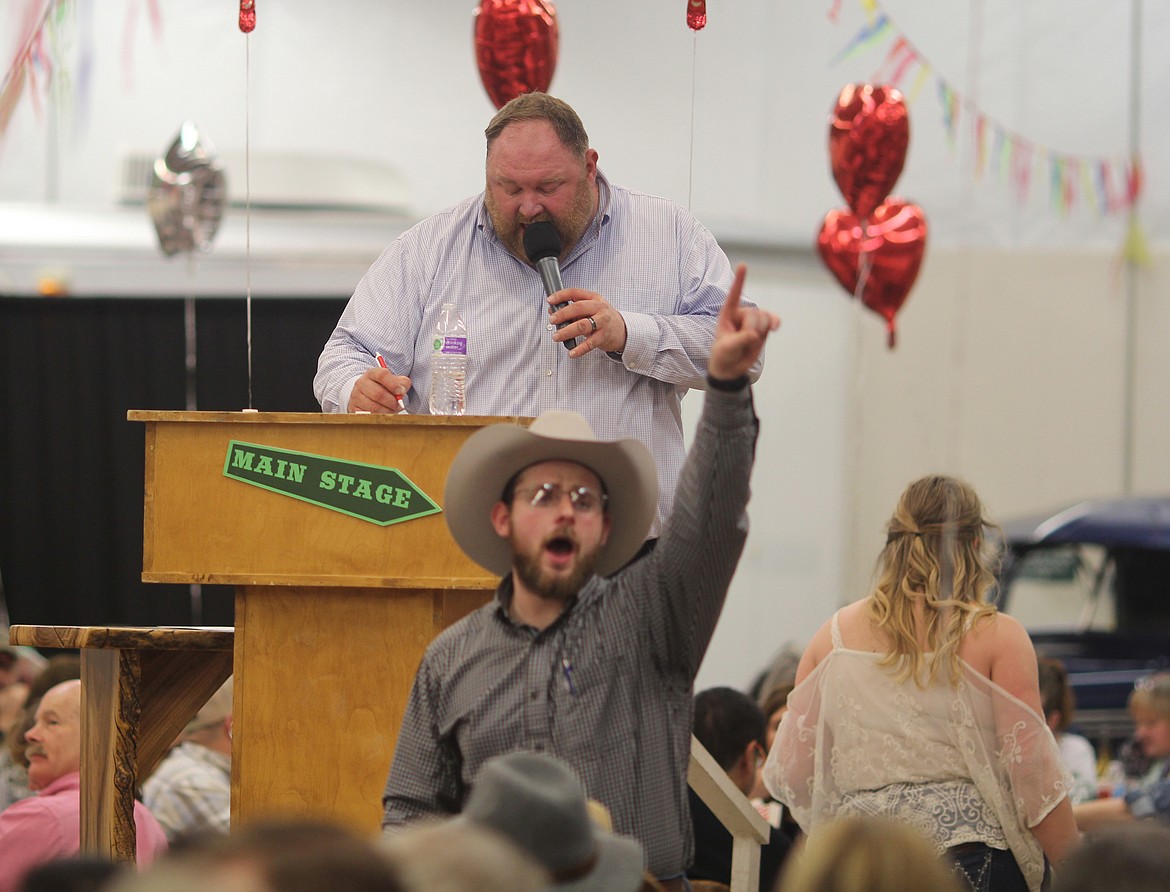 Auctioneer Chuck Yarbro (back) records the bids, while auctioneer Jacob Barth (front) identifies the bidders during the 2020 Country Sweethearts event, a fundraiser for the Columbia Basin Cancer Foundation.