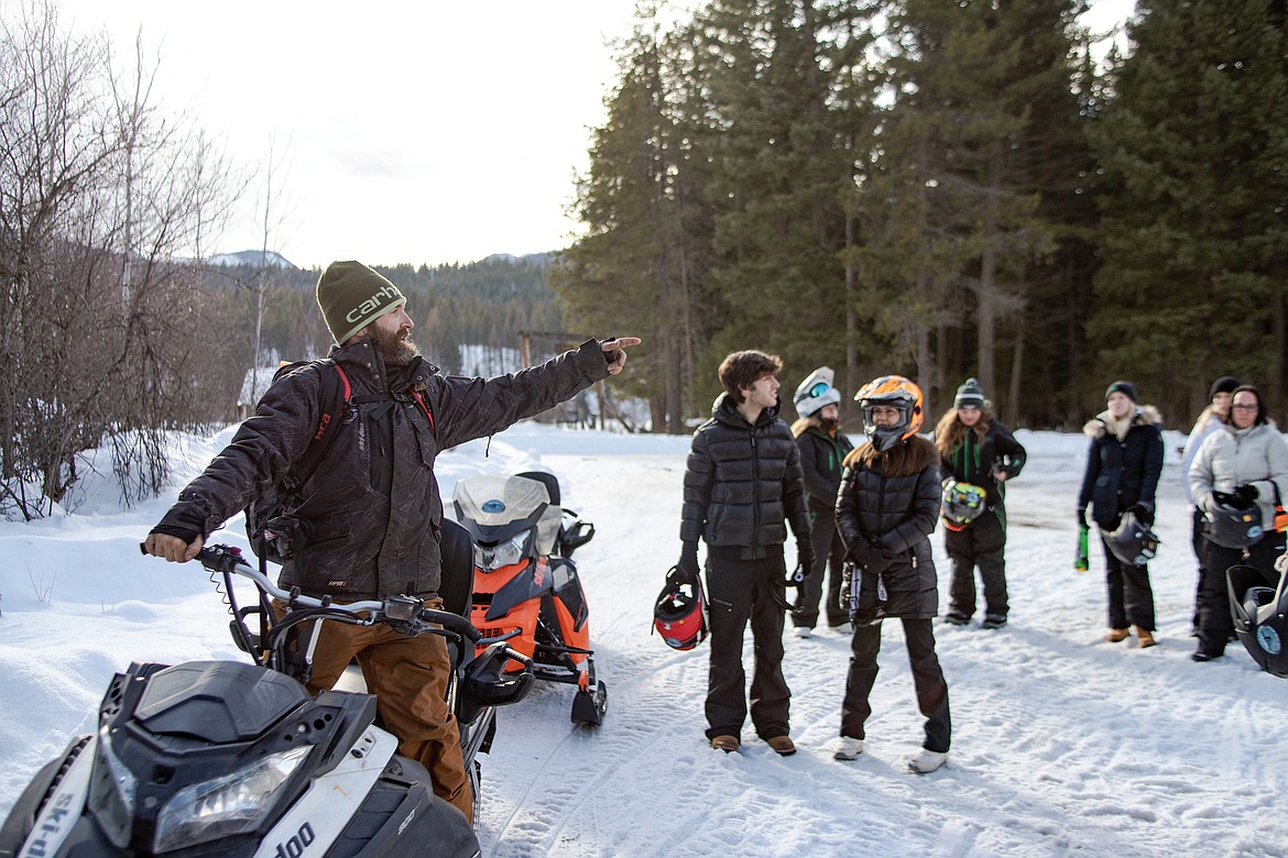 Swan Mountain snowmobile guide Roger Reed leads a full group on safety and instructions on how to use a snowmobile during a tour on Monday. (JP Edge photo)