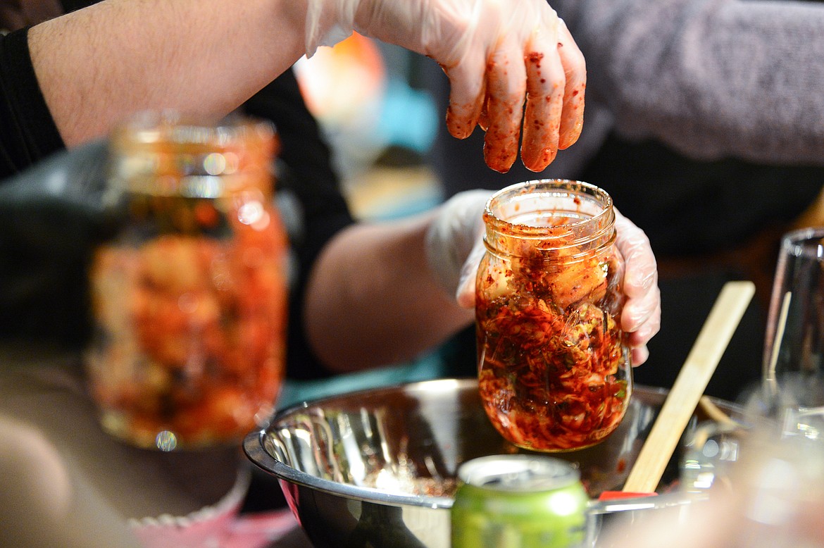Participants put their kimchi into jars for fermentation during a hands-on cooking class with chef John Evenhuis at Trovare in Whitefish on Tuesday, Jan. 18. (Casey Kreider/Daily Inter Lake)