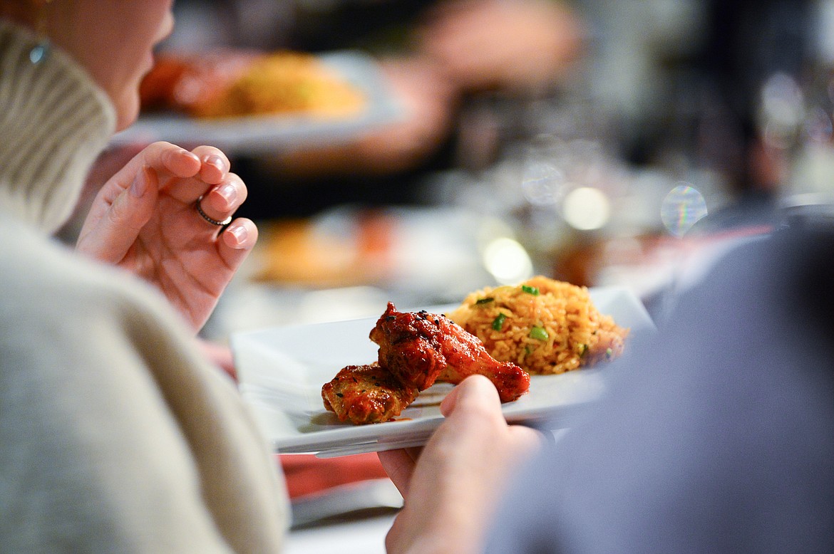 Attendees pass around plates of Kimchi Fried Rice & Korean Chicken Wings during a hands-on cooking class with chef John Evenhuis at Trovare in Whitefish on Tuesday, Jan. 18. (Casey Kreider/Daily Inter Lake)