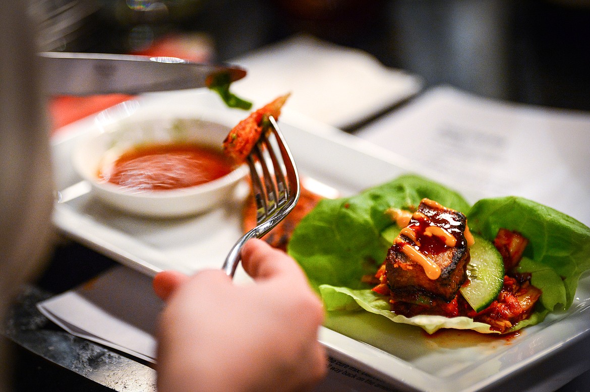 Attendees dig in to their Kimchi Pancake & Braised Pork Belly Lettuce Wraps during a hands-on cooking class with chef John Evenhuis at Trovare in Whitefish on Tuesday, Jan. 18. (Casey Kreider/Daily Inter Lake)