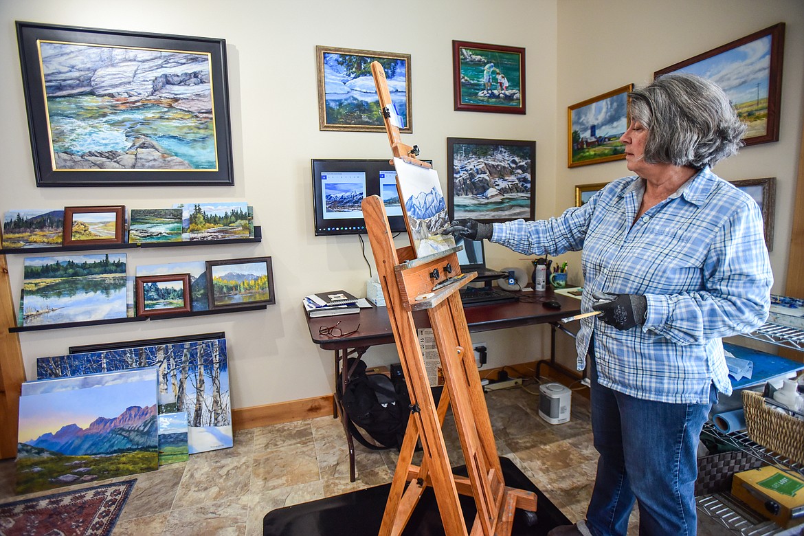 Artist Therese Ely works on a painting tentatively titled "Paradise Valley Backroad" at her home studio in Creston on Thursday, Jan. 20. (Casey Kreider/Daily Inter Lake)