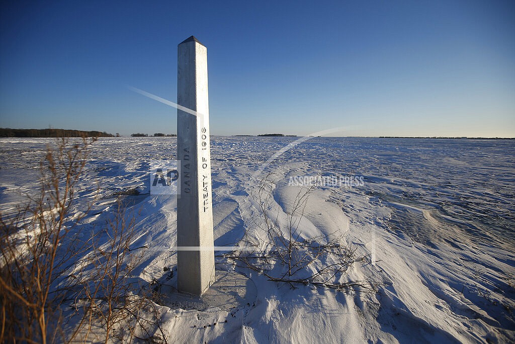 A border marker, between the United States and Canada is shown just outside of Emerson, Manitoba, on Thursday, Jan. 20, 2022. A Florida man was charged Thursday with human smuggling after the bodies of four people, including a baby and a teen, were found in Canada near the U.S. border, in what authorities believe was a failed crossing attempt during a freezing blizzard. The bodies were found Wednesday in the province of Manitoba just meters (yards) from the U.S. border near the community of Emerson. (John Woods/The Canadian Press via AP)