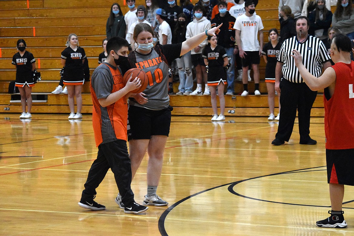 Ephrata High School’s Kacie Shannon (10) helps direct Johnny Graham (11) toward the hoop during the Unified matchup against Othello High School on Wednesday.
