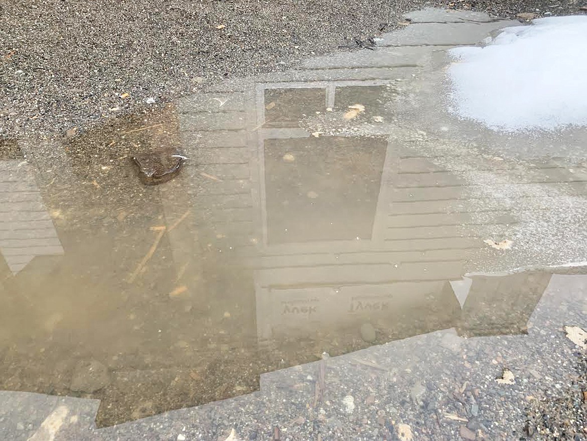 A home being built at Riviera Place in Coeur d'Alene near Atlas Waterfront Park is reflected in a puddle on Thursday.