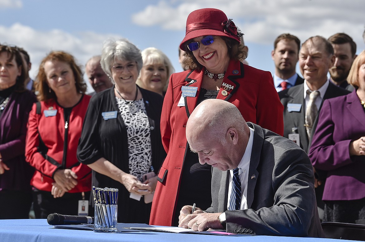 Republican Gov. Greg Gianforte signs one of three bills restricting access to abortion in Montana as sponsor of one of the bills, state Rep. Lola Sheldon-Galloway, R-Great Falls, looks on in Helena. Mont., on April 26, 2021.(Thom Bridge/Independent Record via AP, File)