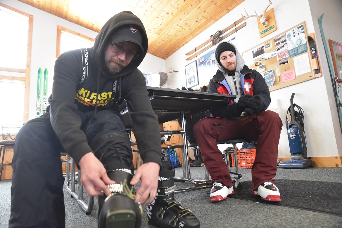 Joe Cherry, left, and Ryan Newby strap on gear before a run on Turner Mountain Ski Area. Cherry has worked alternatively as a cook and ski instructor on the mountain while Newby is on his third season as a member of the Ski Patrol. (Derrick Perkins/The Western News)