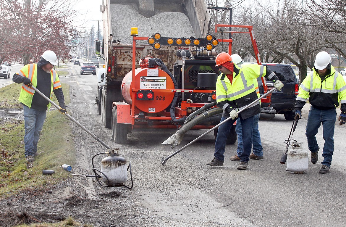 City crews work to fill potholes on Ramsey Road Friday.