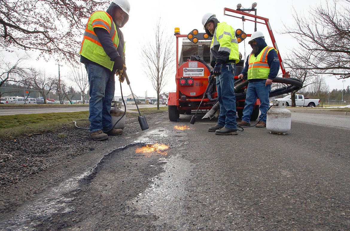 City crews work to fill potholes on Ramsey Road Friday.