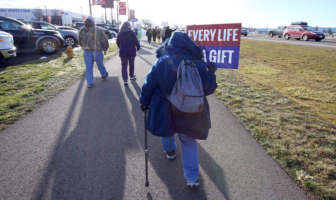 A woman carries a sign along U.S. 95 during Saturday's Right to Life march in Coeur d'Alene.